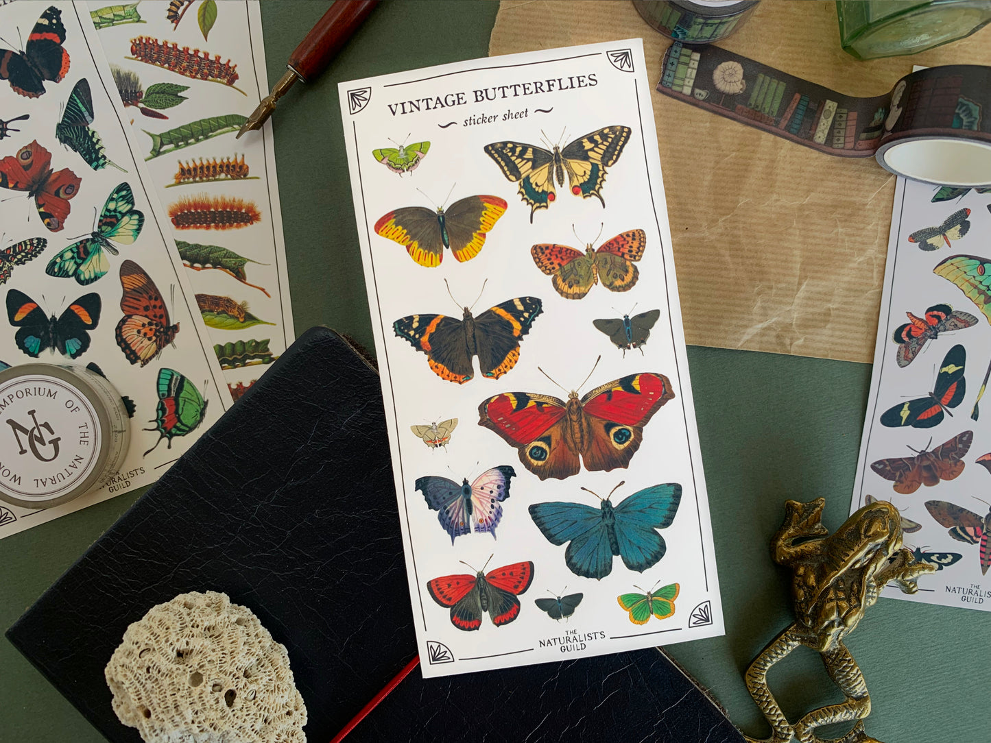 Sticker sheet of butterfly species in a detailed and colourful vintage illustration style, with stationery in the background. The Naturalist's Guild.